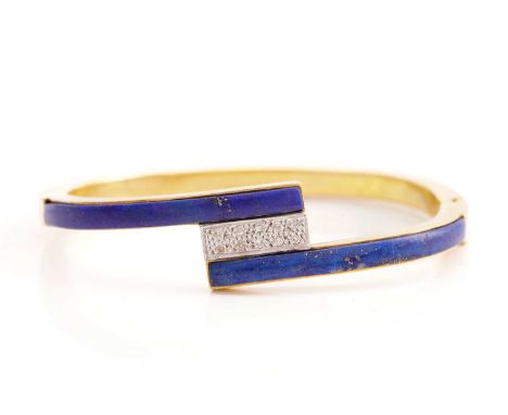 A lapis lazuli and diamond hinged bangle, half of the hoop comprises curved lapis lazuli inlays crossing over each other, wit