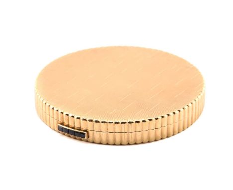 Kutchinsky - a powder compact in 9ct yellow gold, the round and scalloped compact comprises engine-turned cover and base, wit