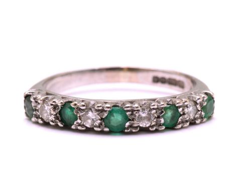 An Emerald and diamond half eternity ring in 18ct gold, with five round faceted emeralds alternating with four diamonds, with