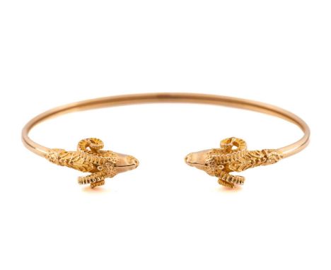 A Rams head flex torque bangle with two yellow metal (tests as 18ct) rams heads measuring 10mm at their widest on a double ho