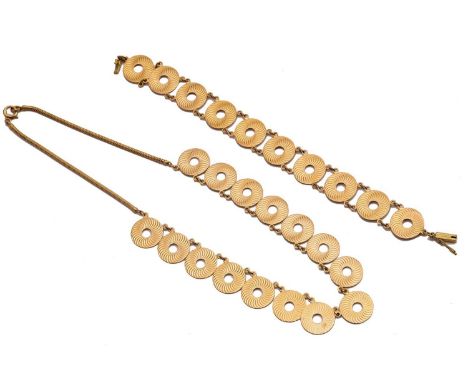A necklace with annular discs and a matching bracelet; the necklace comprises circular discs with engine-turned whirlpool spi