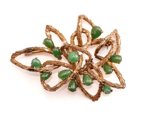 A modernist brooch set with jade, comprises a textured mount of a stylised lotus form, claw-set round and pear-shaped jade ca