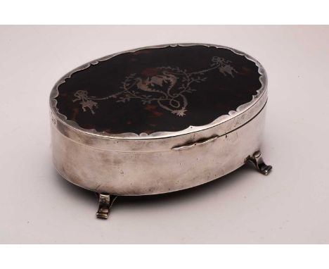 An Edwardian silver and tortoiseshell dressing table box; oval, the tortoiseshell cover inlaid with festoons and swags; and o