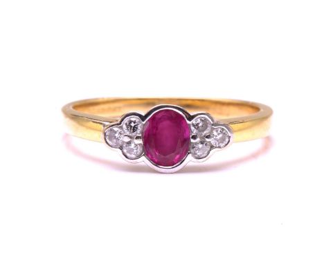 A ruby and diamond ring in 18ct gold, presenting an oval faceted ruby in the centre, flanked by brilliant-cut diamonds set as