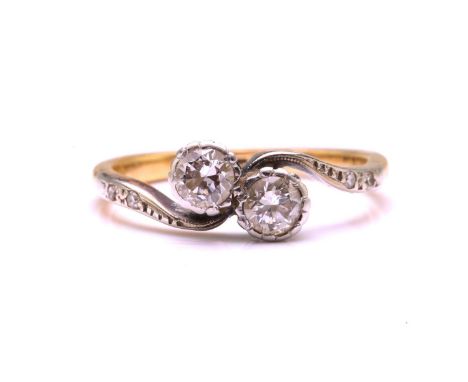 A diamond Toi et Moi crossover ring, adorned with twin old-European cut diamonds in the centre with smaller diamonds chasing 