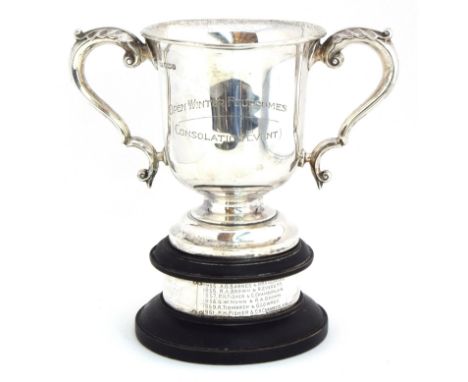 A twin handled trophy cup by Walker &amp; Hall, Sheffield 1930, the scrolling handles with acanthus decoration, raised on a s