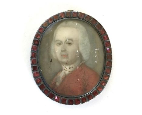 British School, an 18th century miniature portrait in oval yellow metal frame (af), frame set with 39 faceted garnets, 3x4cm