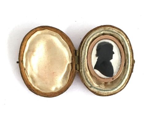 An early 19th century miniature silhouette portrait on ivory with yellow metal brooch mount (af), complete with red leather c