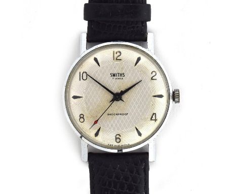A SMITHS 1950s GENT'S STEEL WATCHSilvered fancy engine turned dial, raised Arabic numerals on evens, dagger hands, 7J, diamet