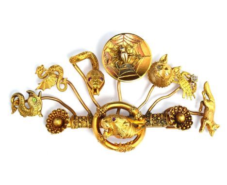 An unusual yellow metal and gold brooch, the original bar features a lion with ruby eyes to which has been soldered various s