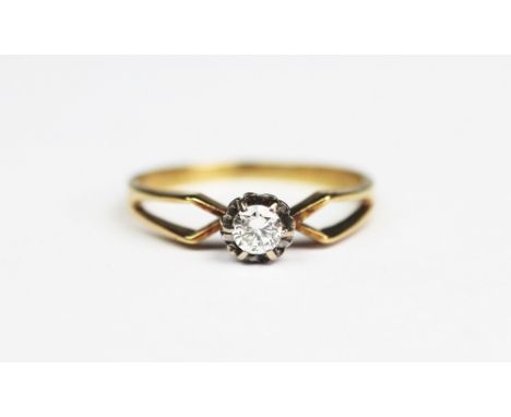 A diamond solitaire ring, the brilliant cut diamond within illusion white metal setting, bifurcated yellow gold shoulders and