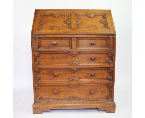 A carved oak bureau, with fielded fall above two short and three long drawers on bracket feet, 100cm H x 77cm W x 45cm D, PRO