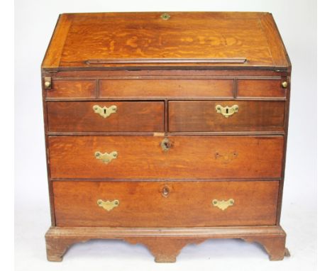 A George III oak bureau, with fall enclosing a fitted interior, above two short and two long drawers, on bracket feet, 100cm 