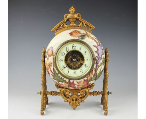 A 19th century gilt metal and pottery mantel time piece, the circular florally relief moulded case enclosing a circular chapt