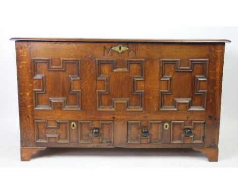 An 18th century oak mule chest, with fielded panel front and two drawers below, on bracket feet, later carved 'MW', 76cm H x 