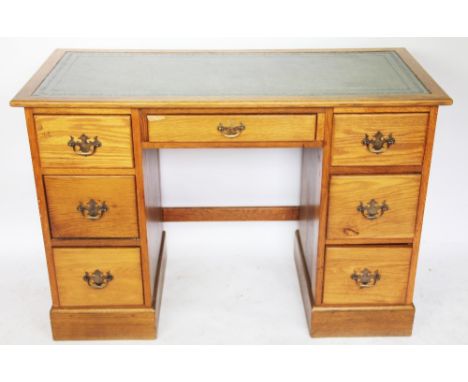 An early 20th century light oak pedestal desk, with an arrangement of seven drawers, on plinth base, 77.5cm H x 112cm W x 52c