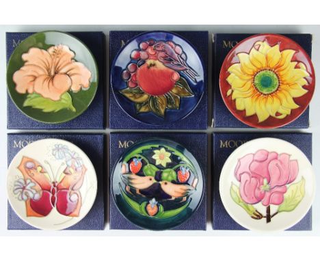 A collection of six Moorcroft pin dishes comprising; Hibiscus against a green ground, Ivory Magnolia 1995, Sunflower 1995, St