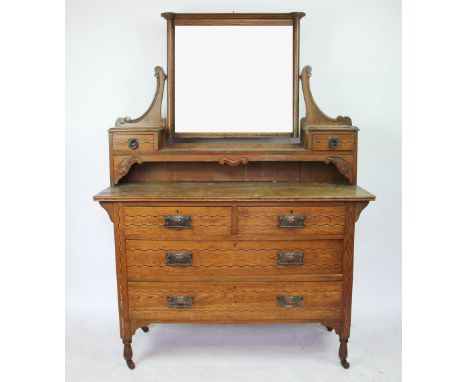 A Victorian Arts and Crafts inlaid oak dressing table, with swing mirror above two short and two long drawers on turned legs,