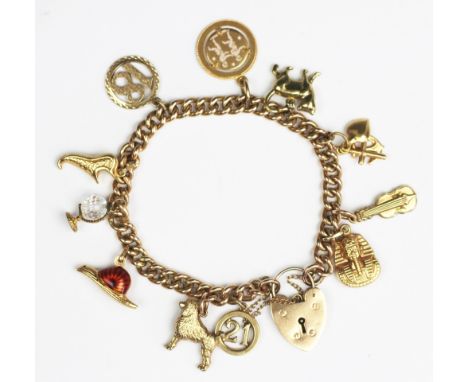 A 9ct yellow gold solid curb link bracelet with attached charms, hung with eleven charms, to include; a red enamelled snail s