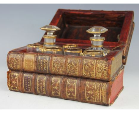A 19th century cased decanter and liqueur set, converted from four antiquarian bound books,  enclosing two gilt decanters and