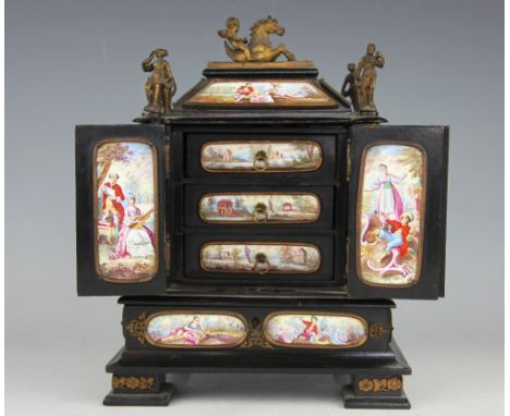 A 19th century Viennese enamel and ebonised miniature table cabinet, enclosing three drawers, set throughout with enamelled r