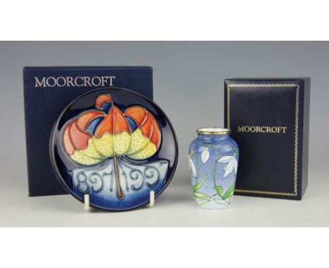 A Moorcroft Centenary pin dish, plate 1897-1997, decorated with a lily and dates, impressed and painted marks, 12cm diameter,
