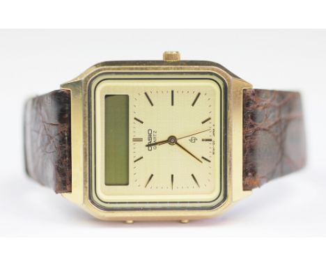 A Casio AT-551G 320 touch screen calculator watch, the gold coloured dial with gold coloured batons hands and centre sweep se