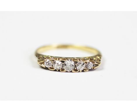 A five stone diamond ring, the five graduated old cut diamonds within boat shaped setting, carved scroll gallery and plain ho