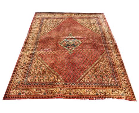 A Persian Sarouk wool carpet, worked with a design of small leaves in red and gold, 194cm x 140cm