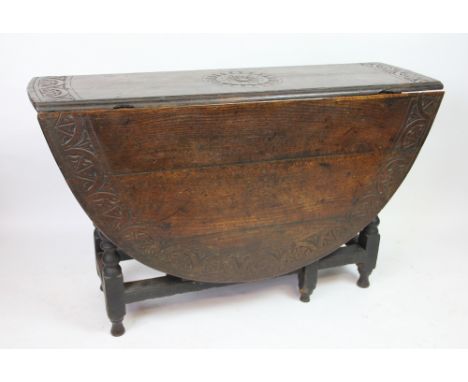 A late 17th century oak gate leg table, with long sword drawer and later carved detailing, on turned legs, 73cm H x 120cm W