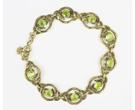 A peridot set 14ct gold bracelet, designed as nine peridot set scroll and floral panels, with attached bolt ring clasp and sa