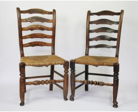 A set of six 19th century beech and ash rustic ladder back dining chairs, with rush seats, on turned legs, 95cm H (6) (at fau
