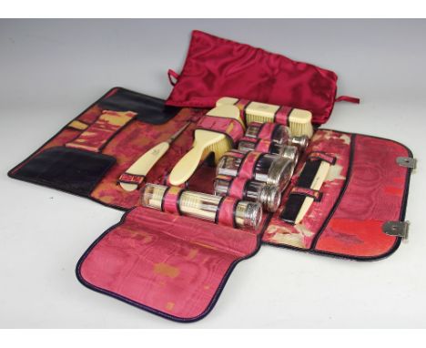 A ladies travelling vanity set, early 20th century, the leather folio type case initialled 'E.H', enclosing a selection of fi