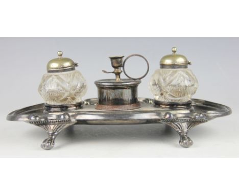 A Victorian silver plated desk stand, of quatrefoil from with a central taper stick holder flanked by two cut glass inkwells,