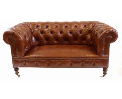 Victorian Chesterfield sofa by Howard, covered in brown leather, deep button upholstering with coiled spring seat, turned mah