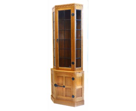 Robert (Mouseman) Thompson floor standing oak glazed corner display cabinet, leaded light, single door covering three fixed g