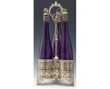 Victorian trefoil electro-plated decanter stand holding three amethyst glass bottles with grape capped cork stoppers, overall