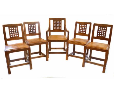 Robert (Mouseman) Thompson four single and one open arm oak framed lattice back dining chairs, each with upholstered leather 