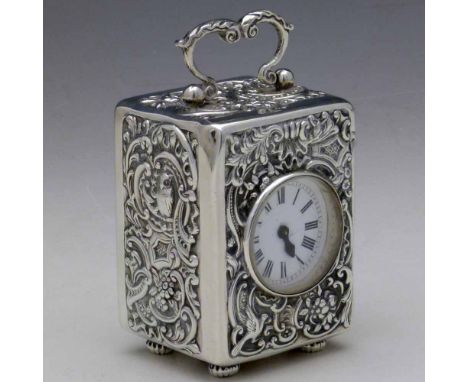 Silver cased miniature carriage clock hallmarked Wm Comyns, London 1895, embossed with rococo scrolls, fitted with a white en