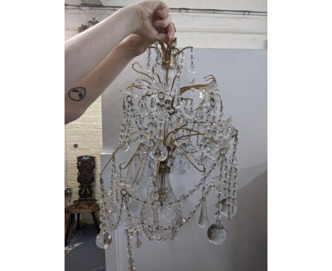 A modern two tier chandelier with decorative glass strange beads with bases with a central glass shade at the bottom of the l