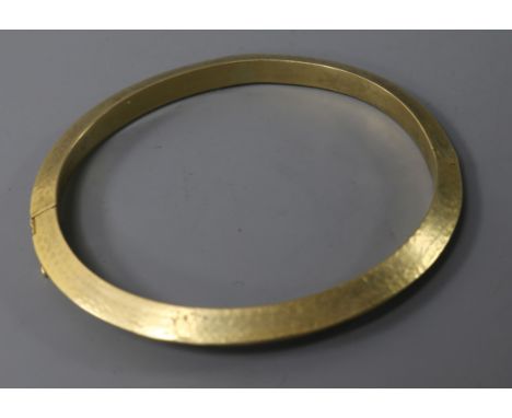 An 18ct gold texture hinged bangle, 18.5 grams.