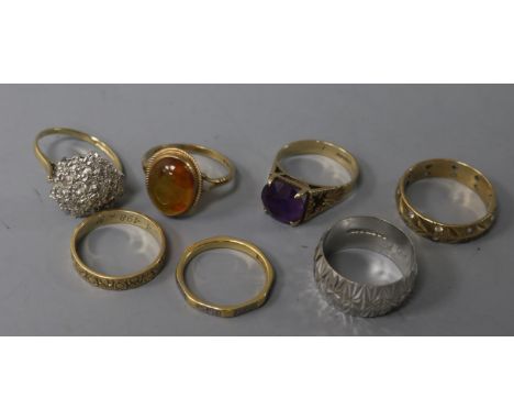 Four various 9ct gold textured rings, one gypsy-set, a 9ct gold and amethyst ring, a similar amber ring and a modernist ring 