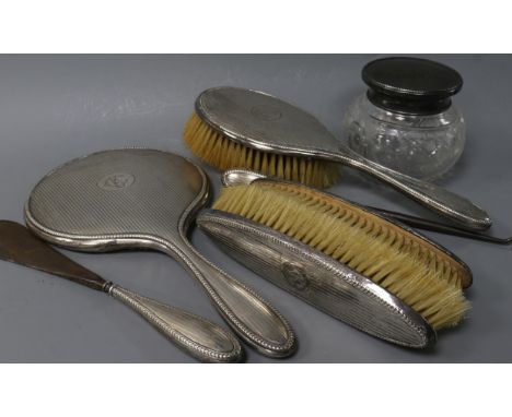 A George V silver-mounted dressing table set, comprising cut glass powder bowl, mirror, two clothes brushes, hair brush, butt