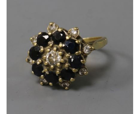 A yellow metal sapphire and diamond cluster ring, size P.