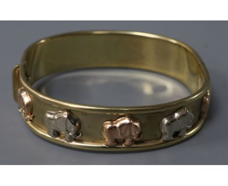 An Italian 9ct gold hinged bangle decorated with elephants, 24.7 grams.