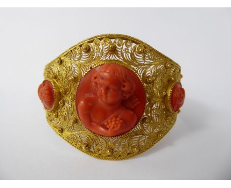 An Antique 18 / 22 ct Yellow Gold and Coral Bracelet, the wire-form double-hinged beaded bracelet set with three classical co