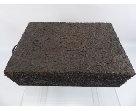 An Antique Indian Carved Wooden Sewing Box, the box having intricate carving to the lid and sides depicting various animals a
