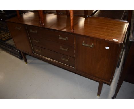A vintage teak effect sideboard having central drawer section flanked by cupboard having stylised brass drawer handles and fe