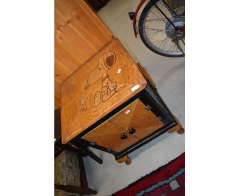 A vintage cabinet having Snoopy and Woodstock marquetry inlay to top