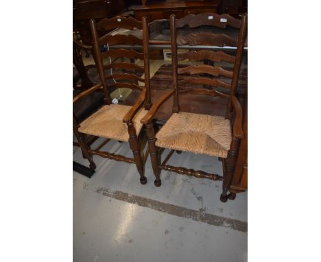 A pair of traditional rush seated ladder back carver chairs